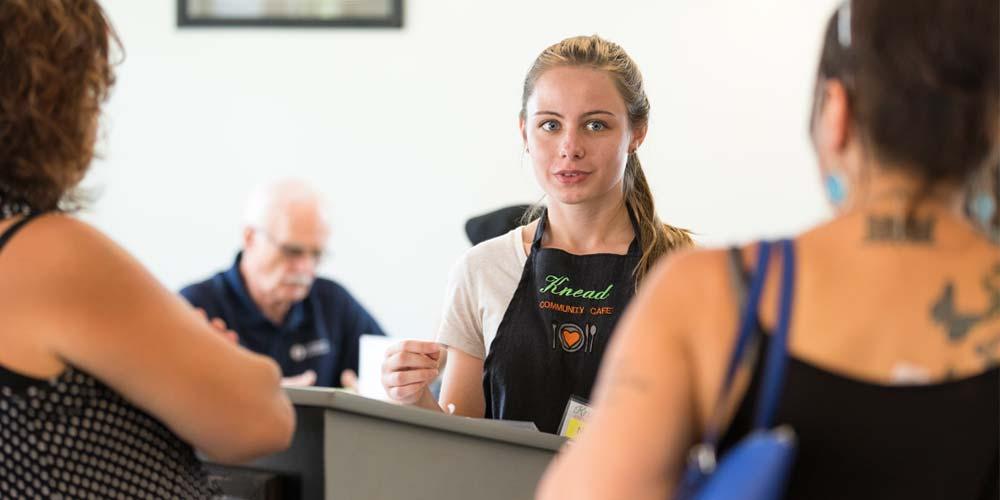 Youth philanthropy interns from CFWC serve meals to customers at Knead Community Cafe in New Kensington, the region's only pay what you can restaurant.